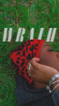 a woman laying in the grass with a hat on her head